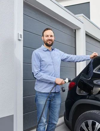Un homme qui recharge sa voiture électrique
